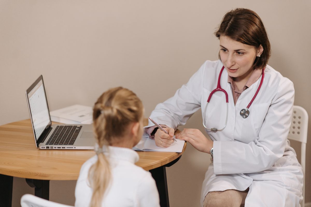 Illustration: Why diagnosis is important in homeopathic treatment — a doctor listening to a patient and taking notes